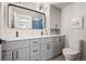 Bright bathroom boasts double sinks, a large mirror, and storage space at 7270 S Jay St, Littleton, CO 80128