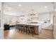 Open kitchen concept showcasing a large island with bar stools, modern lighting, and stainless appliances at 7270 S Jay St, Littleton, CO 80128