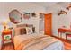Charming bedroom with wood floors, a decorative mirror, and a cozy bed with patterned bedding at 30813 Kings Valley Dr, Conifer, CO 80433