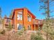 Stunning exterior view of a wood home featuring large windows and a deck with scenic views at 30813 Kings Valley Dr, Conifer, CO 80433