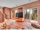 Bright living room with hardwood floors, a large TV, and sliding glass doors leading to outdoor space at 30813 Kings Valley Dr, Conifer, CO 80433