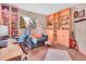 Sunlit home office with lots of storage, desk space and an oversized chair at 30813 Kings Valley Dr, Conifer, CO 80433