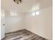 Basement area with plank flooring, white walls, and natural light from windows at 695 S Quitman St, Denver, CO 80219