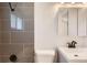 Modern bathroom features sleek gray tiles in the shower and a stylish vanity with black fixtures at 695 S Quitman St, Denver, CO 80219