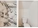 Modern bathroom featuring a marble-tiled shower with a built-in shelf and a separate toilet area at 695 S Quitman St, Denver, CO 80219