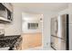 Open kitchen view with stainless steel appliances and hardwood floors in the adjacent living area at 695 S Quitman St, Denver, CO 80219