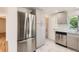 Beautiful kitchen with stainless steel refrigerator, gray cabinets, and elegant marble-patterned floors at 695 S Quitman St, Denver, CO 80219