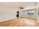 Inviting living room with hardwood floors, white walls, and a ceiling fan, leading to the kitchen at 695 S Quitman St, Denver, CO 80219