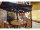 Outdoor patio under a black umbrella with lighting, wreath and comfortable seating at 801 Confidence Dr # 2, Longmont, CO 80504