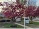 Landscaped front yard with blooming trees and a 'For Sale' sign, creating an inviting curb appeal at 2621 S Federal Blvd, Denver, CO 80219
