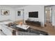 Bright living room featuring a large sectional sofa, modern decor, and wood laminate flooring at 2621 S Federal Blvd, Denver, CO 80219