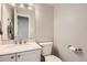 Powder room featuring a white vanity with light countertop and a round mirror at 49950 Oak Park Dr, Bennett, CO 80102
