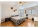 Bright bedroom featuring vaulted ceiling, ceiling fan, wood floor, and decorative wall shelving at 49950 Oak Park Dr, Bennett, CO 80102