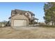 Spacious two-story home with neutral siding, brick accents and a two-car garage surrounded by an expansive front yard at 49950 Oak Park Dr, Bennett, CO 80102