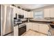 Well-lit kitchen featuring stainless steel appliances, white cabinets, and granite countertops for an ideal cooking space at 49950 Oak Park Dr, Bennett, CO 80102