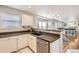 Bright kitchen with stainless steel appliances, sleek white cabinets and breakfast bar overlooking the living room at 49950 Oak Park Dr, Bennett, CO 80102