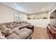 Finished basement featuring plush couches, wood floor, and shuttered window at 49950 Oak Park Dr, Bennett, CO 80102