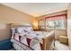Warm bedroom featuring a quilt bed, wooden headboard, and a dresser with a mirror at 6367 Xavier St, Arvada, CO 80003