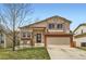 Charming two-story home with well-maintained lawn, covered porch with seating and two-car garage, nestled in a residential neighborhood at 6367 Xavier St, Arvada, CO 80003