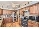 Well-lit kitchen featuring stainless steel appliances, granite countertops and wooden cabinets at 6367 Xavier St, Arvada, CO 80003