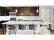 Modern kitchen featuring dark cabinetry, stainless steel appliances, and a large island with seating at 2366 Central Park Blvd, Denver, CO 80238