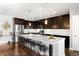 Spacious kitchen with a large island, stainless steel appliances, dark cabinets, and modern pendant lighting at 2366 Central Park Blvd, Denver, CO 80238