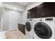 Well-organized laundry room with modern washer and dryer, dark cabinets, and ample storage space at 2366 Central Park Blvd, Denver, CO 80238
