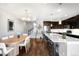 Open-concept living area with hardwood floors, modern lighting, an adjacent staircase, and a gourmet kitchen at 2366 Central Park Blvd, Denver, CO 80238
