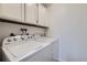 Bright laundry room with washer and dryer and overhead storage cabinets at 62 Newark St # D, Aurora, CO 80012