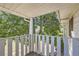 A cozy patio framed by a white railing, offering glimpses of lush greenery at 62 Newark St # D, Aurora, CO 80012
