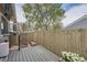 Cozy backyard deck with wooden fence, mature tree and small gated entrance at 4028 Ames St, Wheat Ridge, CO 80212