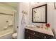 Clean, well-lit bathroom features a vanity, decorative mirror and shower-tub combo at 4028 Ames St, Wheat Ridge, CO 80212