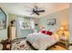 Cozy bedroom features a ceiling fan, light green walls and a floral rug at 4028 Ames St, Wheat Ridge, CO 80212