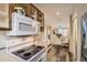 Well-lit kitchen with stylish stove top, microwave, open cabinets, and clear view to the dining room at 4028 Ames St, Wheat Ridge, CO 80212