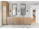 Luxurious bathroom with double vanities, custom wood cabinetry, and modern lighting fixtures at 5326 Lions Paw St, Castle Rock, CO 80104