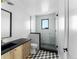 Stylish bathroom with a glass-enclosed shower, modern fixtures, and unique geometric tile flooring at 5326 Lions Paw St, Castle Rock, CO 80104