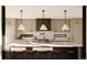 Bright kitchen features an island with a white countertop, seating, and pendant lighting at 5326 Lions Paw St, Castle Rock, CO 80104