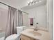 Well-lit bathroom features a shower-tub combo and single sink vanity with a large mirror above the sink at 5976 S Jellison St # E, Littleton, CO 80123