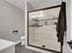 Modern bathroom featuring a walk-in shower with glass door, sleek fixtures, and gray accents at 5976 S Jellison St # E, Littleton, CO 80123
