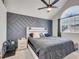 Bedroom with vaulted ceiling, accent wall, arched window, ceiling fan, and neutral decor at 5976 S Jellison St # E, Littleton, CO 80123