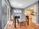 Dining room with seating for four leading into an adjacent kitchen space with wood cabinets at 5976 S Jellison St # E, Littleton, CO 80123