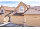 Charming home featuring a tan exterior, two-car garage, tiled roof, and arched window on the upper level at 5976 S Jellison St # E, Littleton, CO 80123