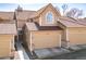 Charming home featuring two-car garage, tan siding, beautiful tiled roof, and lovely arched window above the garage at 5976 S Jellison St # E, Littleton, CO 80123