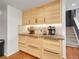 Eat-in kitchenette with wood cabinets, granite counters, wine storage, and a view of the stairs to the second floor at 5976 S Jellison St # E, Littleton, CO 80123