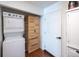 Laundry room with stacked washer/dryer and wood storage cabinet for organizing cleaning supplies at 5976 S Jellison St # E, Littleton, CO 80123