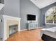 Bright living room featuring a fireplace, hardwood floors, a large window, and light gray walls at 5976 S Jellison St # E, Littleton, CO 80123