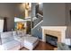 Cozy living room boasts a fireplace, wood floors, plush sectional seating, and an open staircase to upper level at 5976 S Jellison St # E, Littleton, CO 80123