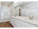 Bathroom features a double vanity, large mirror, and glass-enclosed shower in an all-white aesthetic at 13695 Emerald Lake St, Parker, CO 80138