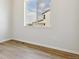Bright bedroom with wood-look floors, a large window offering neighborhood views, and neutral walls at 13695 Emerald Lake St, Parker, CO 80138