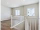 Well-lit hallway with white banister, wood-look floors, and a view of the bright living area at 13695 Emerald Lake St, Parker, CO 80138